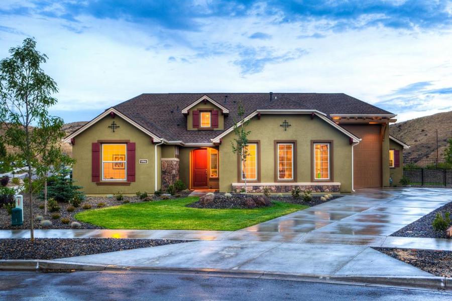 Two-story home with lit windows at dusk