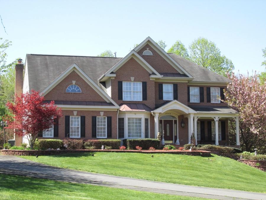Brick two-story home with a manicured lawn